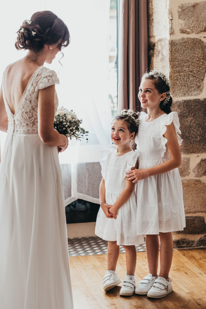 Une mariée et deux enfants d'honneur, habillées tout en blanc